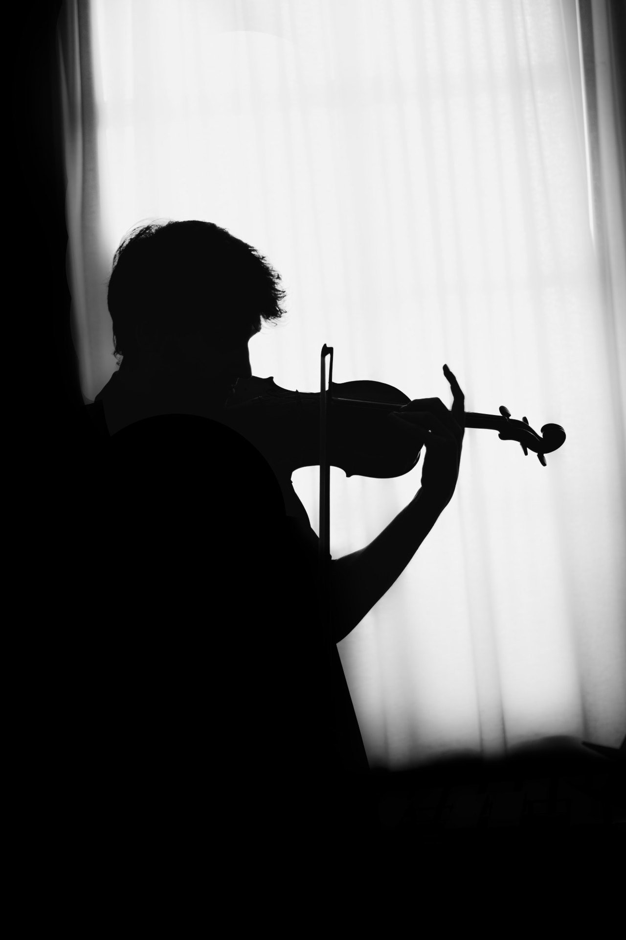 Silhouette de Vassily Chmykov jouant du violon devant une fenêtre